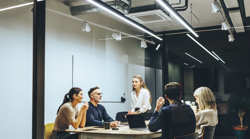 Personnes en réunion sur mezzanine industrielle avec bureaux